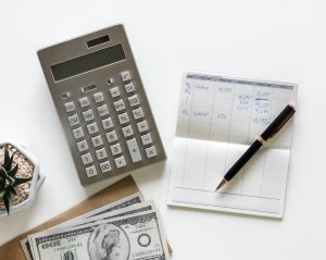 Une calculette, un stylo et un bloc-note pour faire sa comptabilité