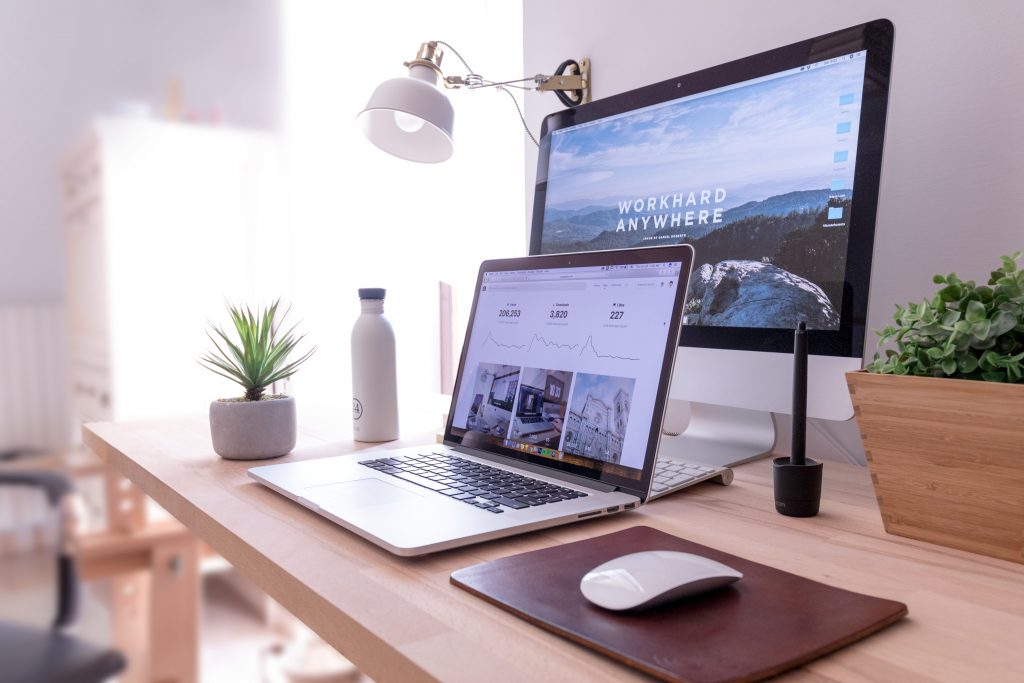 Un ordinateur à double-écran sur un bureau en bois