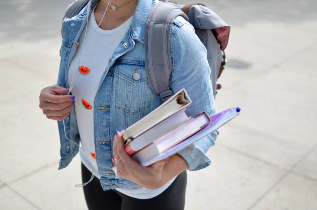 Jeune étudiante qui porte des livres de cours